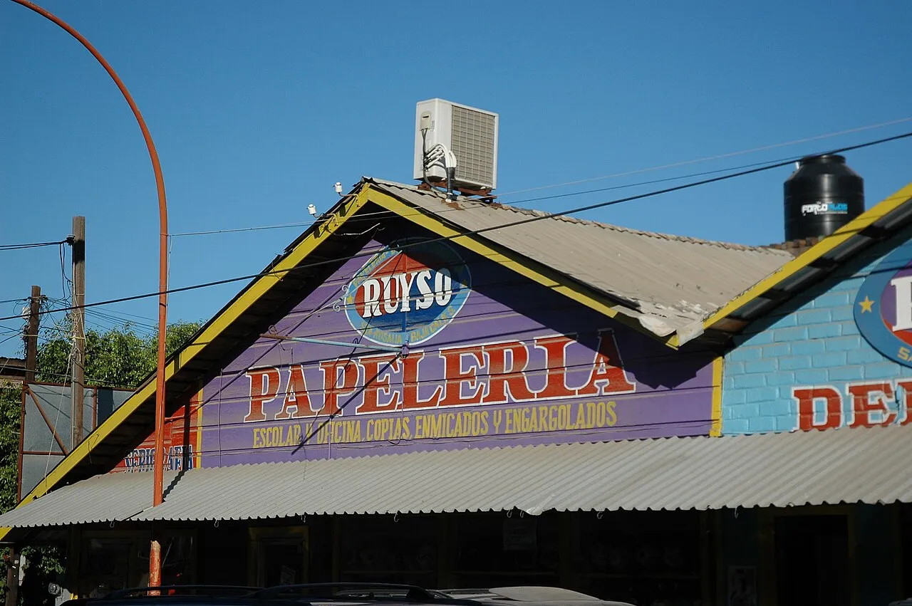 Papelería con el techo pintado de morado y amarillo bajo un cielo azul